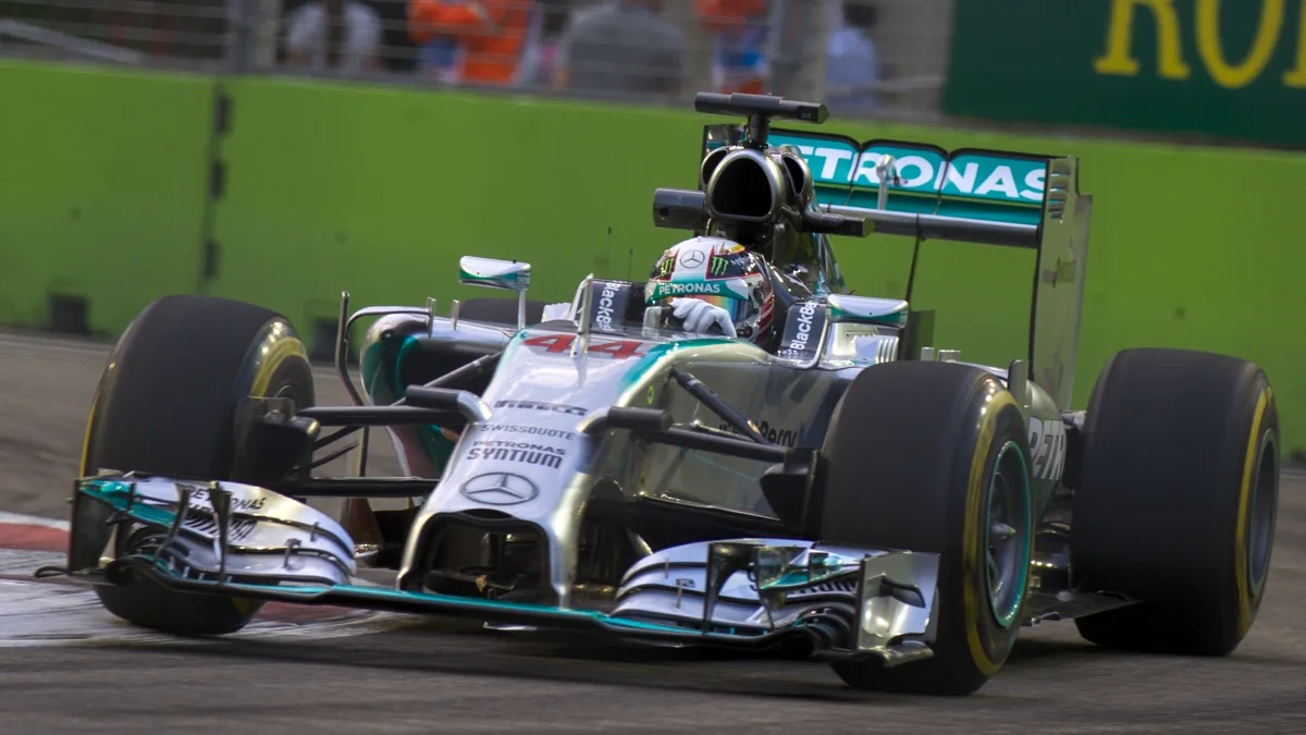 Formula One driver inside cockpit navigating Marina Bay track under extreme heat