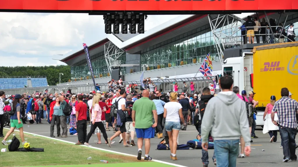 Race weekend spectators wearing functional autumn race weekend paddock outfits along the pit walk