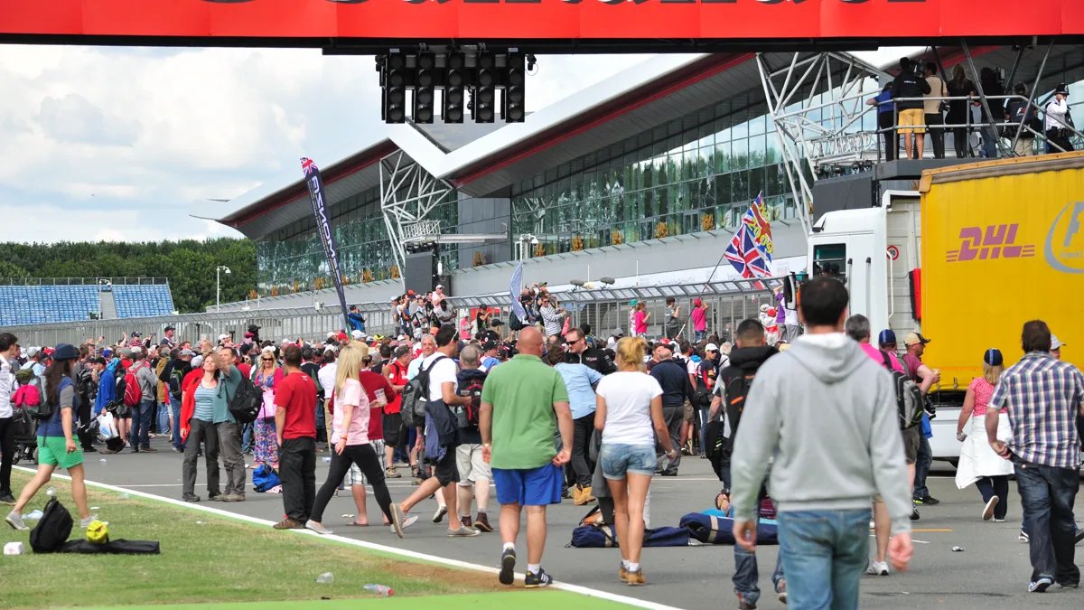 Race weekend spectators wearing functional autumn race weekend paddock outfits along the pit walk