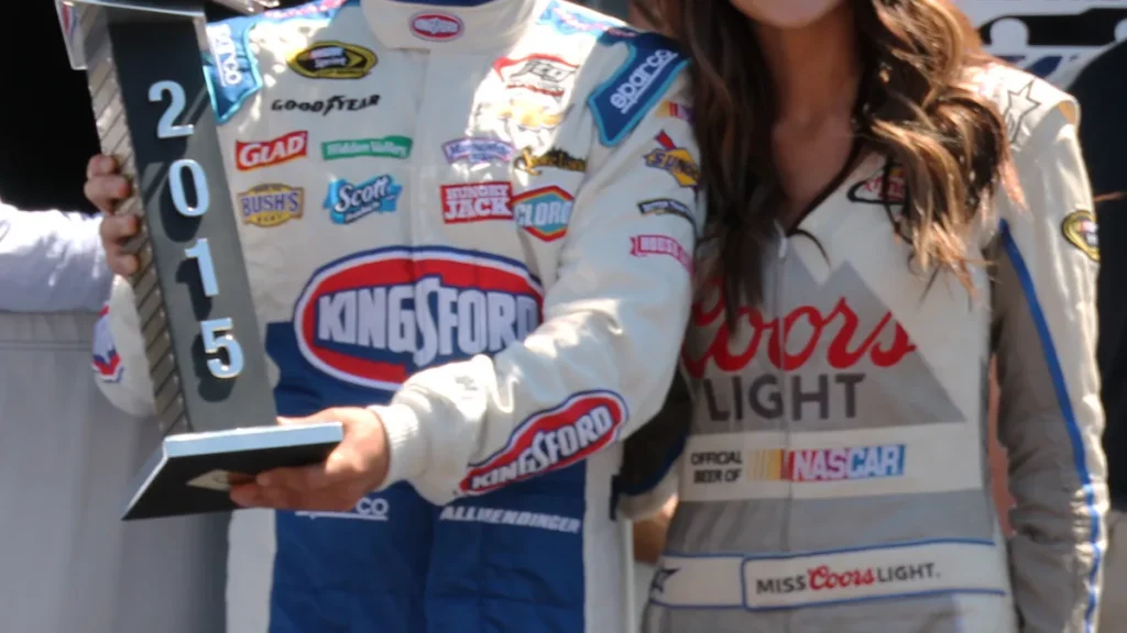 Stock car driver suit display showing chest sponsor patches and belted waist styling