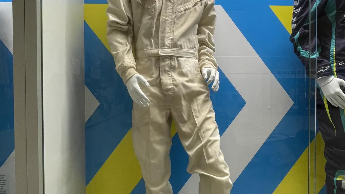 Historic white motorsport driver coverall jumpsuit showing vintage chest sponsor patches